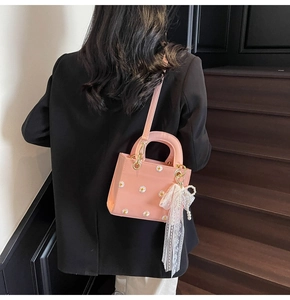 Model view of pink mini tote bag featuring daisy embroidery and white lace bow charm