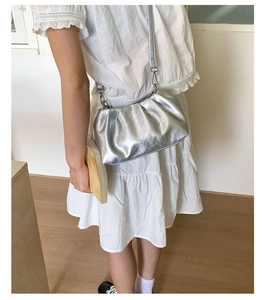 Silver pleated cloud bag with thin strap shown on model for a trendy styling look