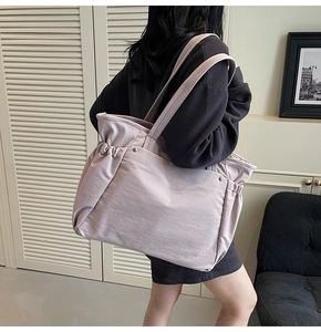 Détail du sac cabas en toile lilas avec plis latéraux et rivets métalliques décoratifs