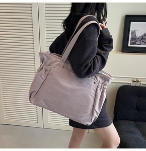 Détail du sac cabas violet en tissu montrant le design plissé latéral et les rivets