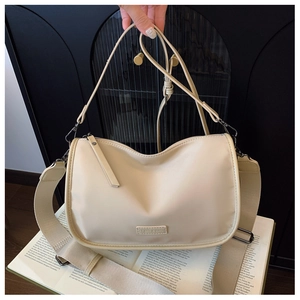 Détail du sac bandoulière minimaliste en nylon beige avec bandoulière réglable en toile