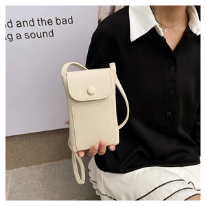 Detail of beige pebble leather phone crossbody bag with round buckle and crossbody strap
