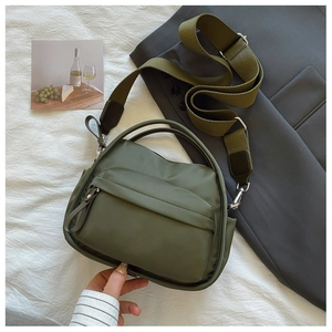 Detail of army green nylon crossbody bag with wide strap and silver metal hardware