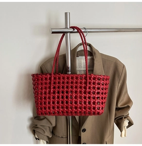 Detail of red woven hollow-out beach bag with intricate grid texture and dual straps