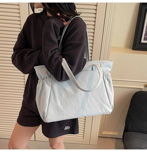 Détail du grand sac cabas en toile bleu clair avec cordon de serrage latéral et texture
