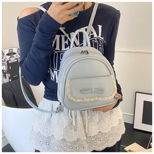 Detailansicht eines hellblauen Minirucksacks mit Spitzenbesatz und eleganter Lederschleife