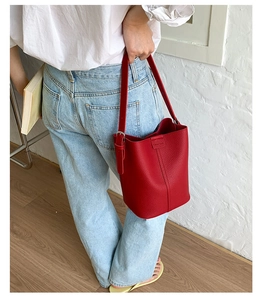 Detail of red leather bucket bag with silver metal buckle and adjustable strap
