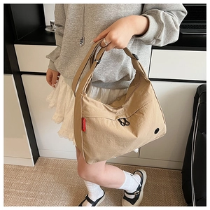 Detail view of khaki nylon crescent bag showing large capacity on a female model