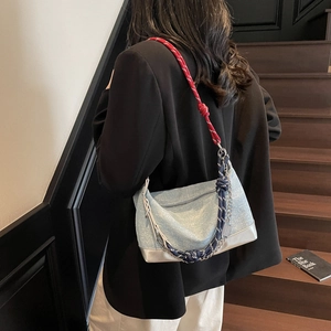 Detail of light blue textured shoulder bag with chic tricolor braided chain strap