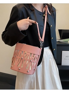 Pink hollow-out leather bucket bag with silver studs and adjustable shoulder strap