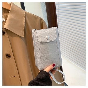Detail of silver textured leather phone bag with magnetic flap in a lifestyle setting