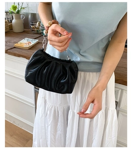 Detail of black pleated cloud handbag with marble beaded handle and silver hardware links