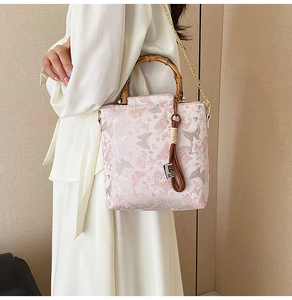 Detail of pink floral jacquard fabric with butterfly embroidery and bamboo handle