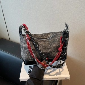 Detail of glitter fabric tote bag featuring red braided rope and silver chain straps