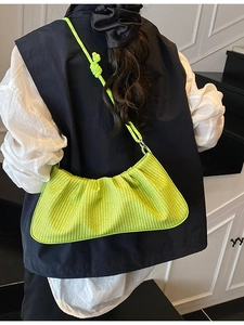Neon green woven ruched crossbody bag with rope shoulder strap shown from back view