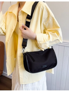 Sac bandoulière noir minimaliste en nylon avec large sangle pour un usage quotidien