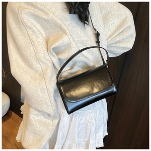 Detail van zwarte vierkante crossbodytas met fijne stiksels en gladde lederen afwerking