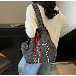 Detail of gray denim tote bag with cat embroidery and a small matching round pouch