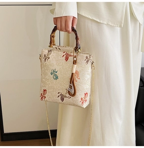 Detail view of lace bead embroidery and natural bamboo handle on the mini crossbody bag