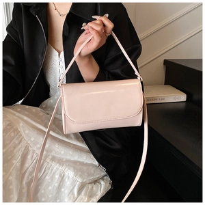 Detailweergave van lichtroze lakslederen crossbodytas met een minimalistisch ontwerp