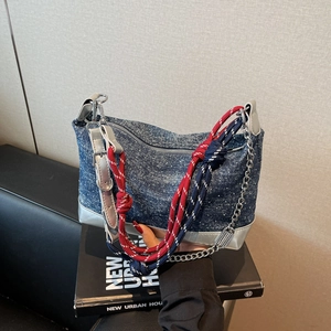 Detail of blue denim tote bag with silver metallic trim and three-in-one shoulder strap