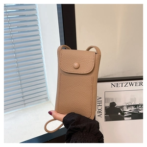 Detail of light khaki lychee pattern leather texture on a compact crossbody phone bag