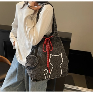 Close-up of a dark grey denim tote bag with white cat embroidery and rope drawstring