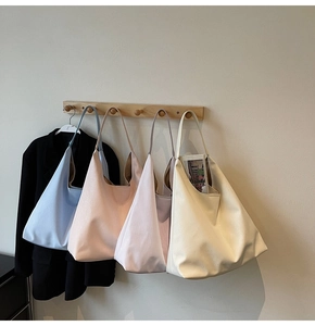 Detail showing four minimalist leather tote bags in blue, pink, purple, and cream colors