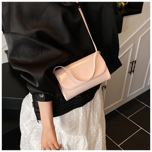 Lichtroze minimalistische crossbodytas gecombineerd met een elegante outfit