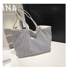 Détail du grand sac cabas en toile rayée montrant la texture et l'étiquette brodée