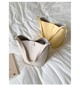 Detail of cream and yellow bucket bags with litchi texture and matching inner pouches