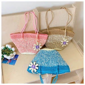 Detailed texture of hand-crocheted straw tote bags with floral accents and long handles