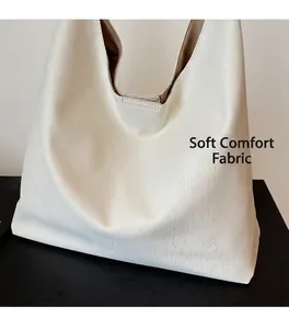 Detail view of the white large tote bag showing textured leather and camel lining