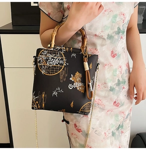 Detail of bamboo handle and metal chain on a black Chinese style lace handbag