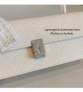 Dettaglio della borsa baguette crema con trama saia e chiusura in strass
