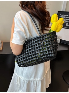 Chic black hollow woven tote bag for beach vacations with stylish mesh pattern