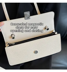 Dettaglio della fibbia magnetica argentata su una borsa a tracolla intrecciata beige