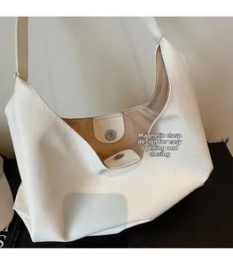 Detailed macro view of white shoulder bag with magnetic closure and interior lining