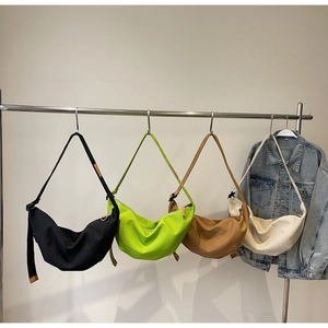 Detailed close-up showing four colorful canvas crescent bags with adjustable straps