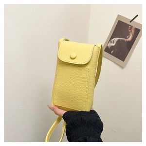 Detail showing bright yellow litchi pattern leather mini crossbody phone bag with clasp