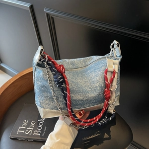 Detail showing light blue denim tote with metallic silver trim and rope knot decorations