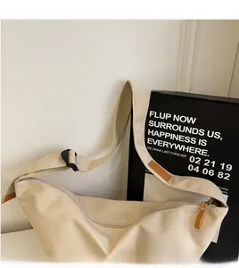 Detail view of beige canvas crossbody bag featuring adjustable strap and secure zipper