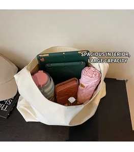 Detailed interior of a white tote bag showing storage for tablet, bottle, and wallet