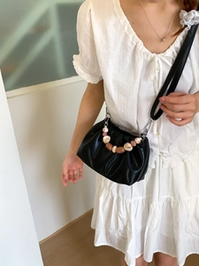 Fashionable black pleated bucket bag with decorative colorful beads and shoulder strap