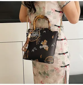 Detailed view of satin handbag featuring bamboo handle and traditional Chinese embroidery