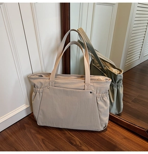 Vue détaillée du grand sac cabas beige avec poches latérales et design spacieux chic