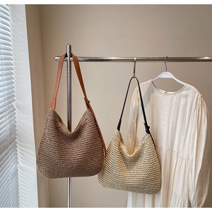 Dettaglio di borse hobo in paglia intrecciata marrone e beige con tracolle in pelle