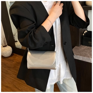 Zilveren glanzende crossbodytas getoond op model voor maat- en stijlreferentie