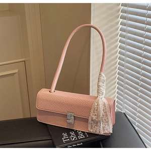 Dettaglio borsa a mano rosa intrecciata con fibbia di diamanti e nastro in pizzo