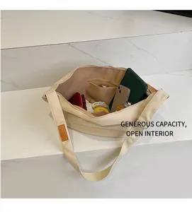 Detail showing the spacious interior of beige canvas tote with zipper pocket and gadgets